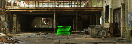 a bright green box sits in large room of an abandoned building